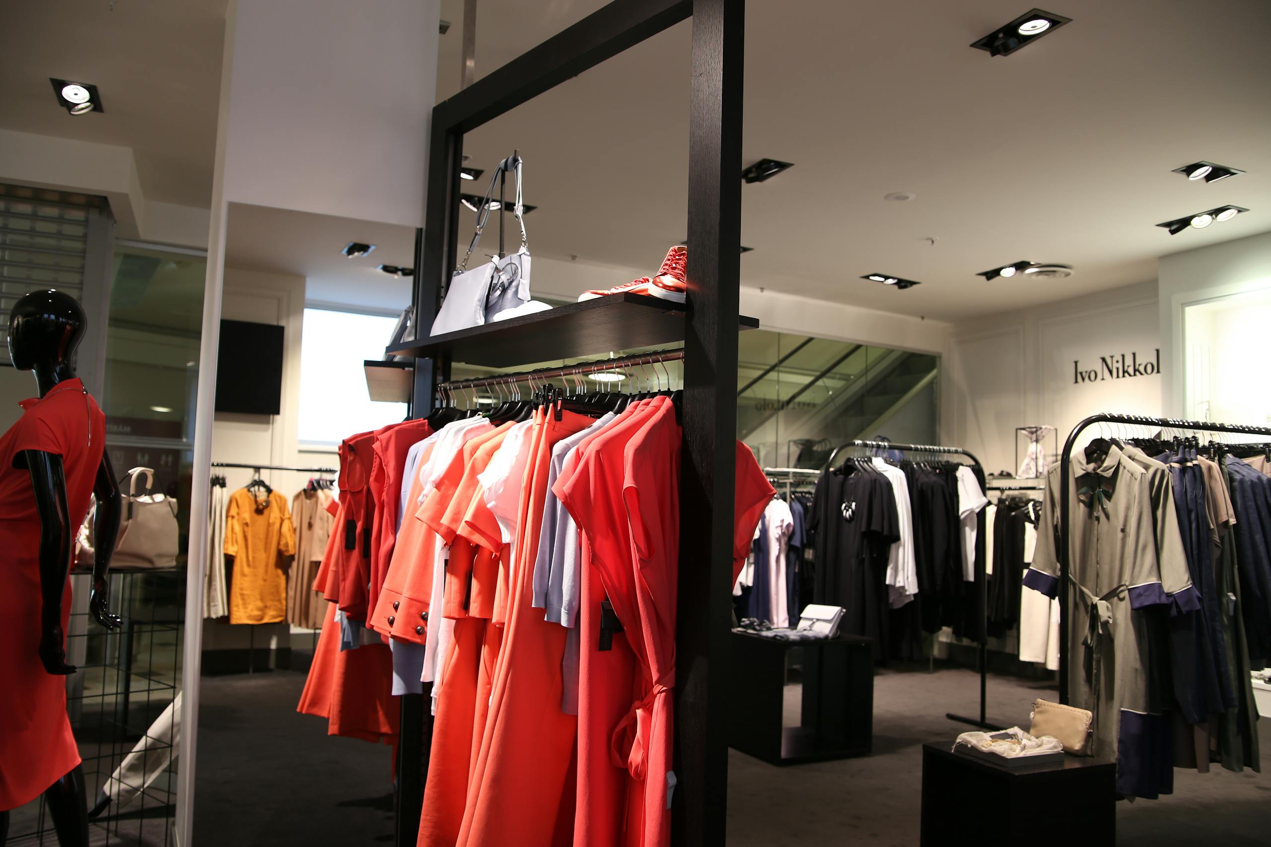 Discover a chic fashion boutique showcasing a variety of colorful clothes on elegant racks.